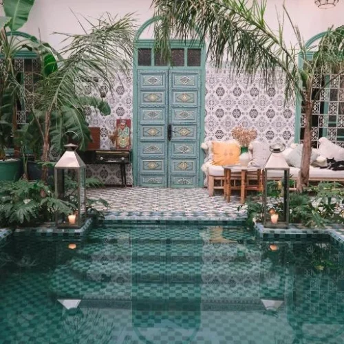 Patio du Riad BE Marrakech avec piscine verte et architecture marocaine traditionnelle